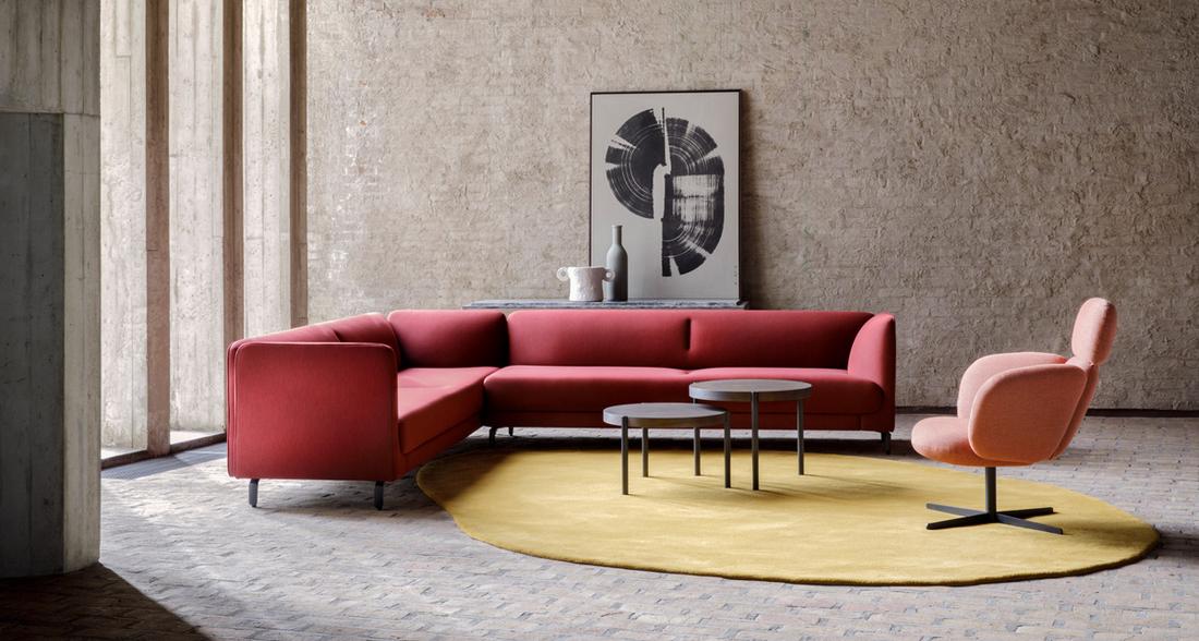 Rood gekleurde bankstel met roze stoel van Artifort op een opvallend rond, geel tapijt. 