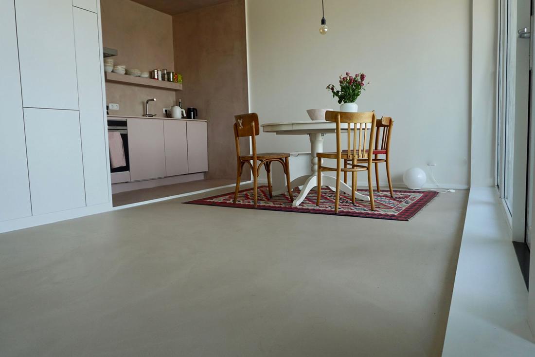 Prachtig! Woonbeton op de vloer en aan de wand in de keuken.