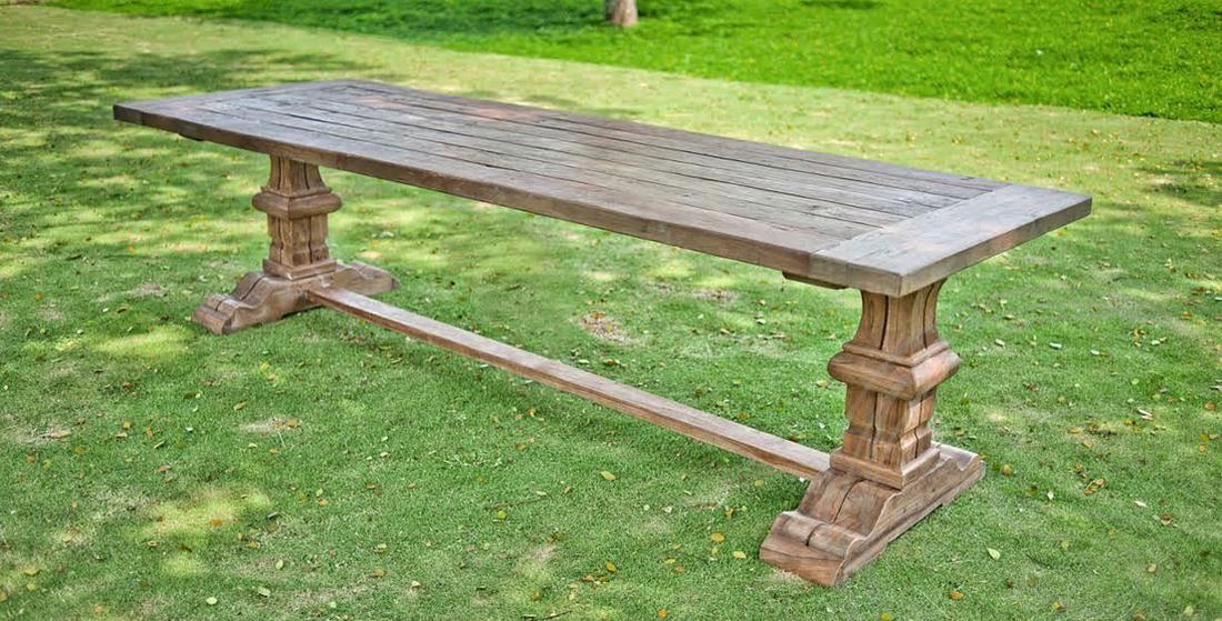 Lange kloostertafel buiten in het gras. 