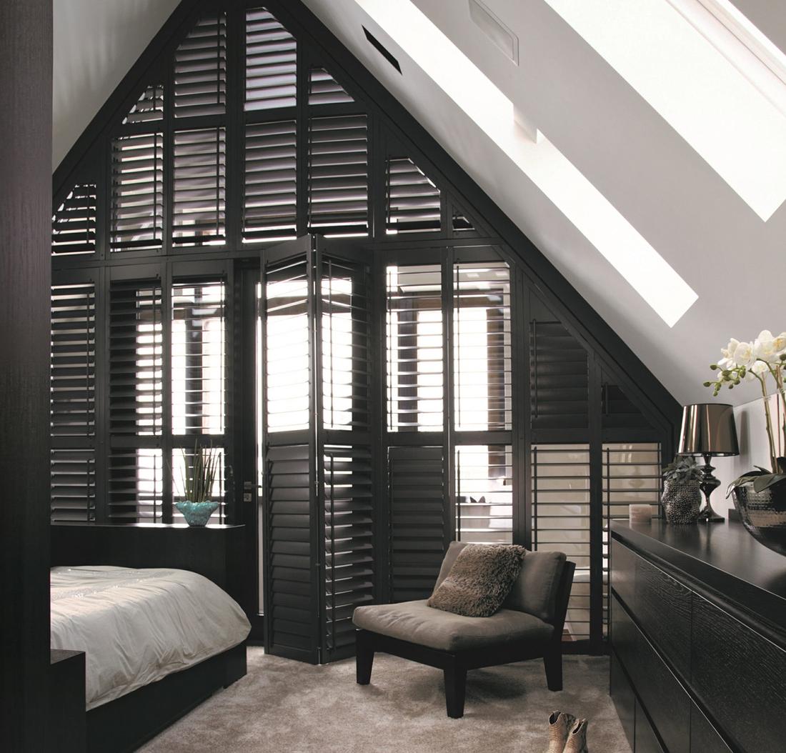 Stijlvolle, zwarte shutters in de slaapkamer als room divider.