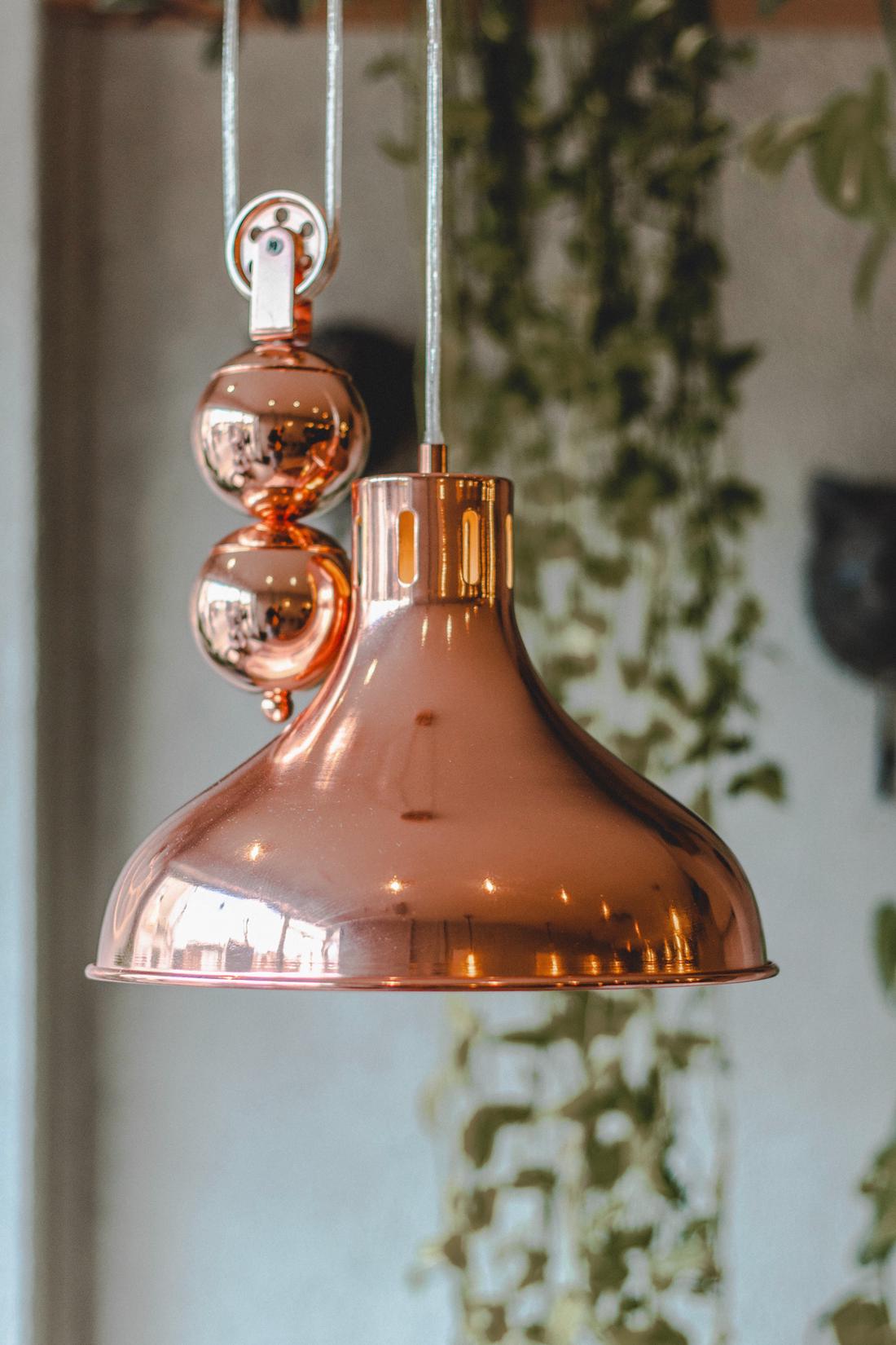 Moderne, vintage hanglamp met een koperen lampenkap met katrol.