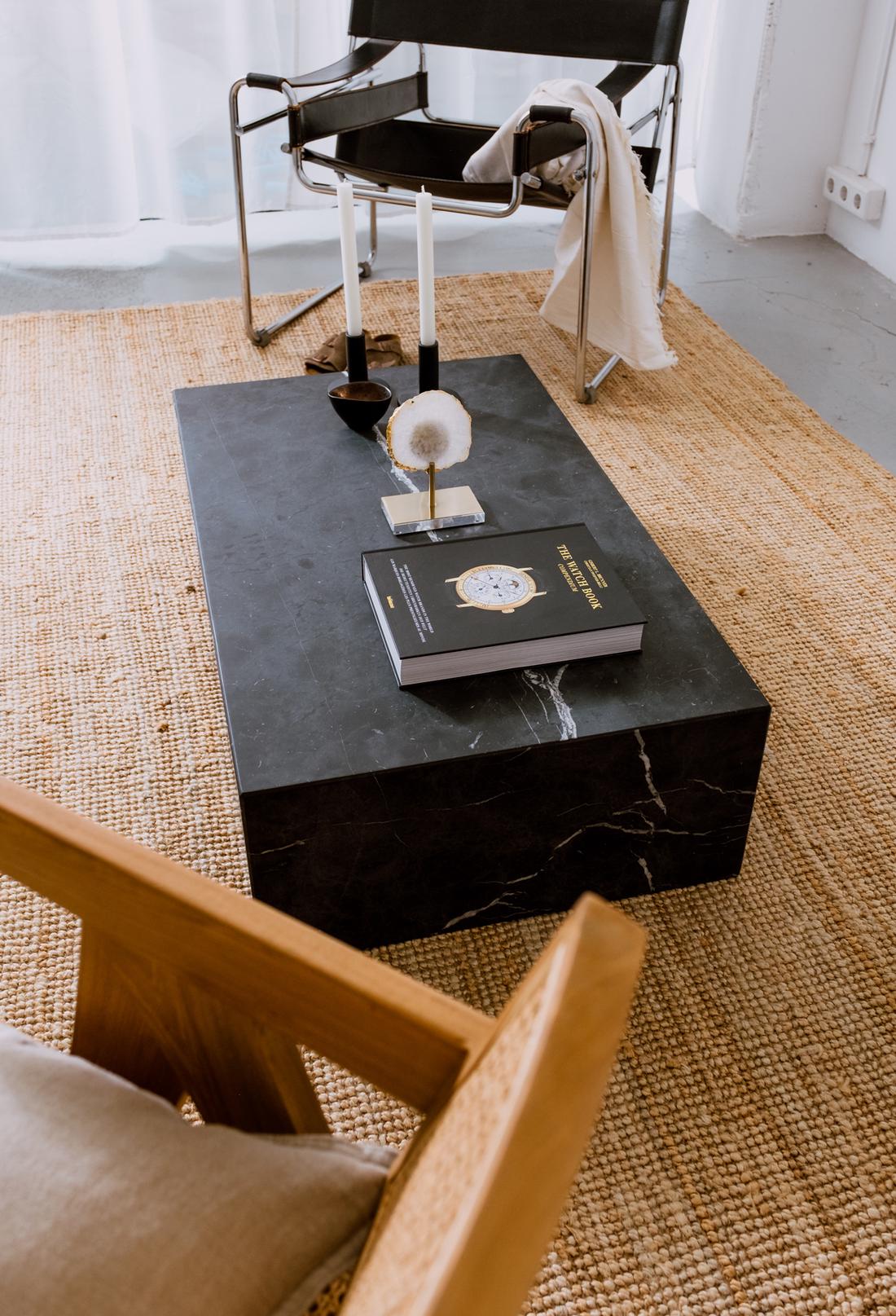 Rechthoekig blok van zwart marmer als salontafel.