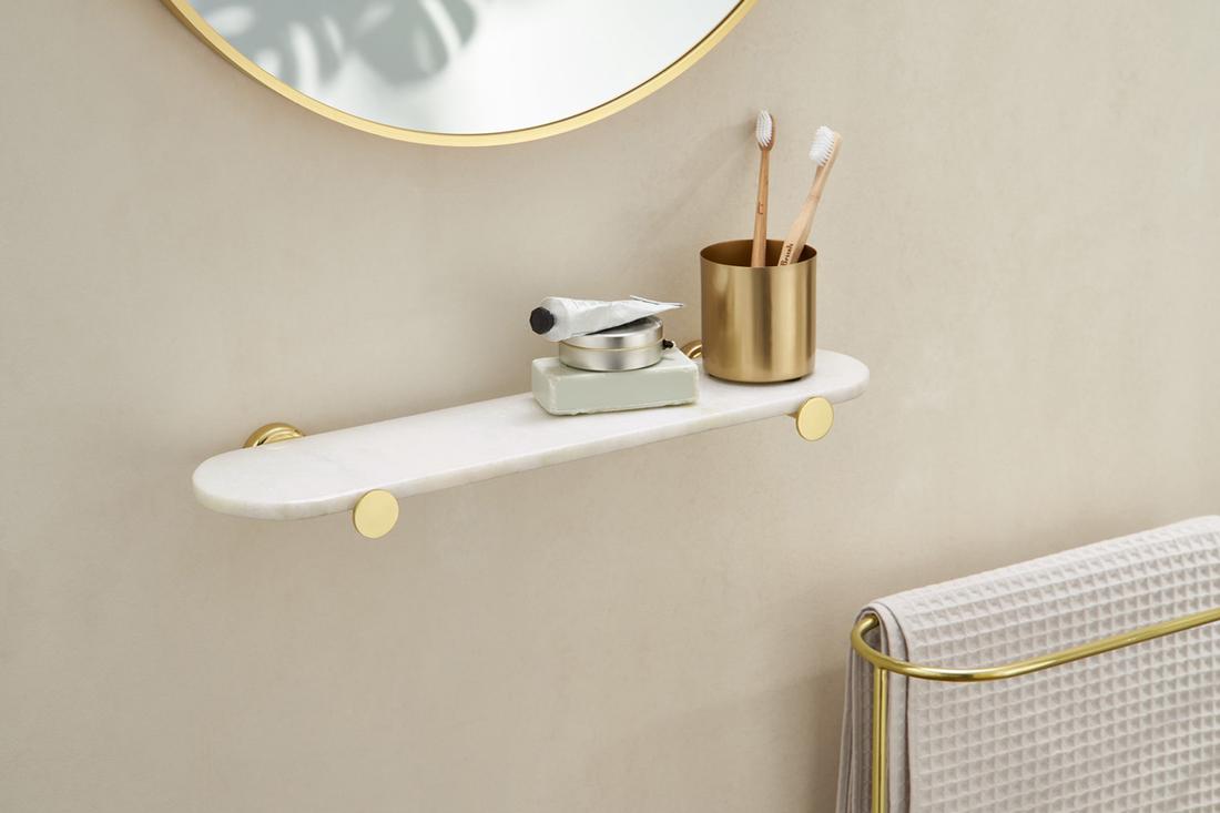 Een wit marmeren planchet Sakari met messing geeft je badkamer een elegante uitstraling.