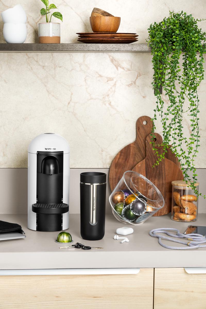 Witte Nespresso Vertuo koffiemachine met bijbehorende accessoires.