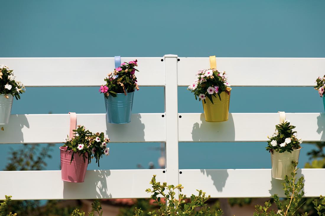 woonhome-tuin-decoratie-schutting-hek-tuinhek-bloempotten-accessoires-vrolijke-kleuren-hangpotten-1