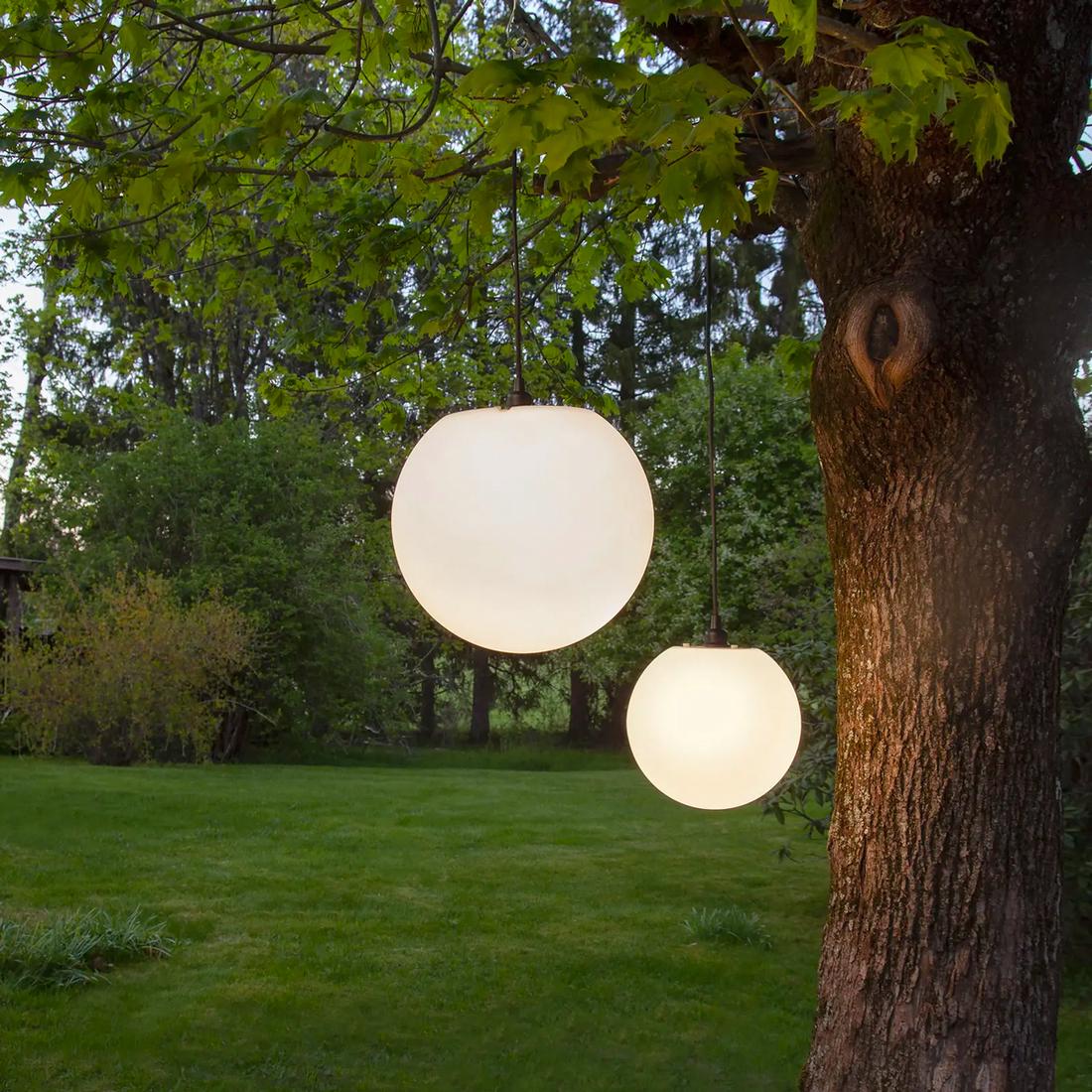 Deze warme bollen zijn net volle maantjes die hangen aan het plafond van de overkapping. Minimalistische en modern volgens de tuinlampentrends 2023. 