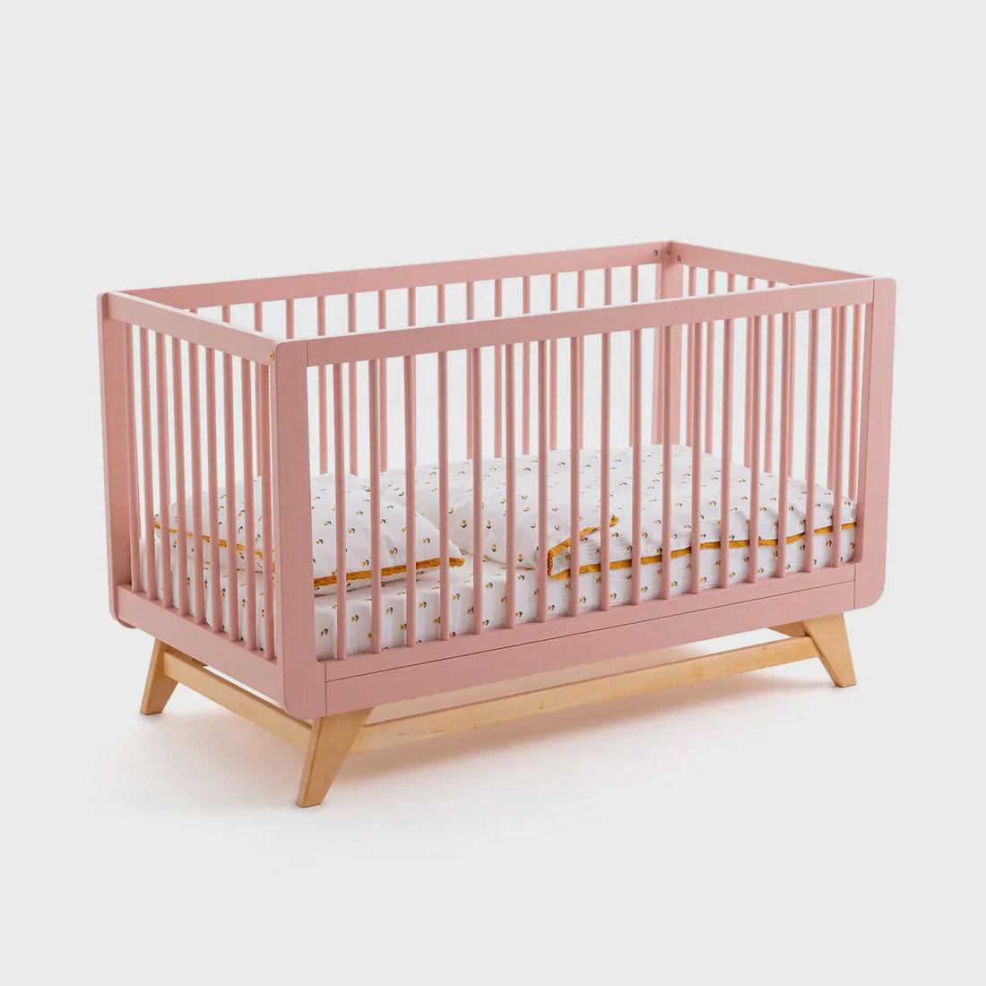 Het poederroze bedje met spijlen houdt je baby veilig in bed, ook als hij of zij al kan staan. 