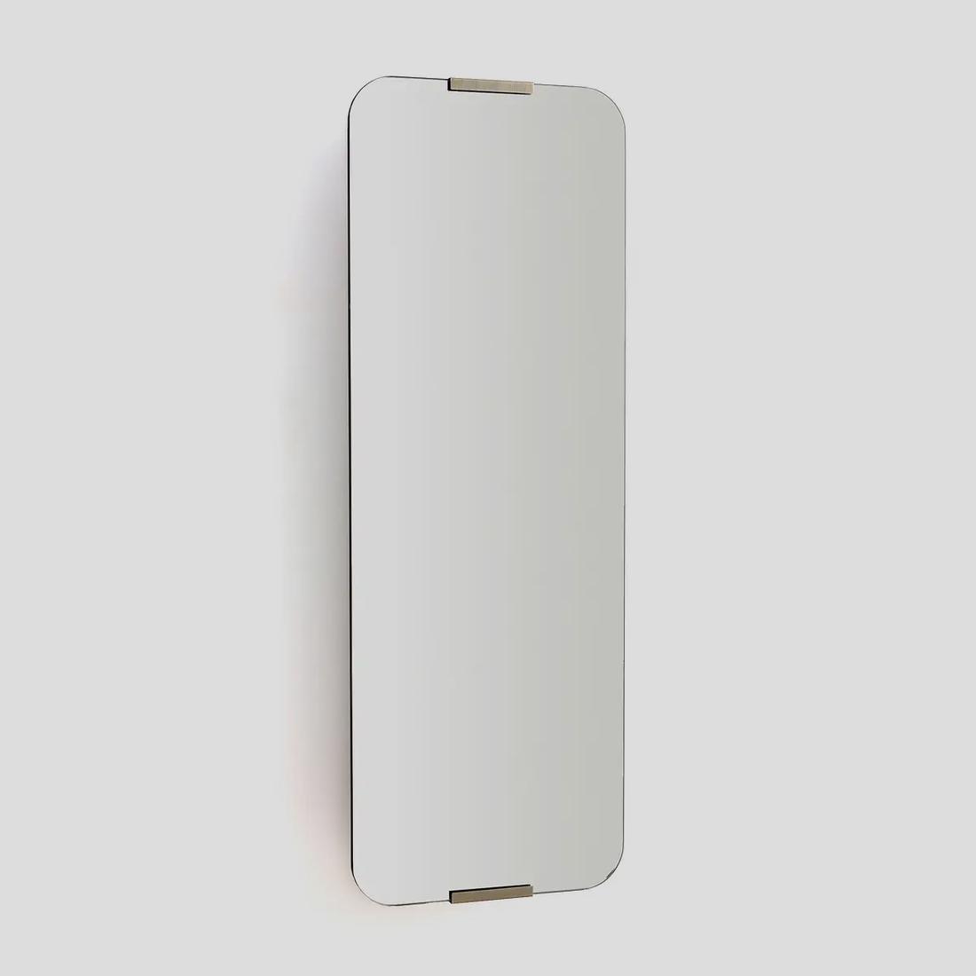 De messing staven accentueren het minimalistische en heldere design van de grote draaispiegel. 