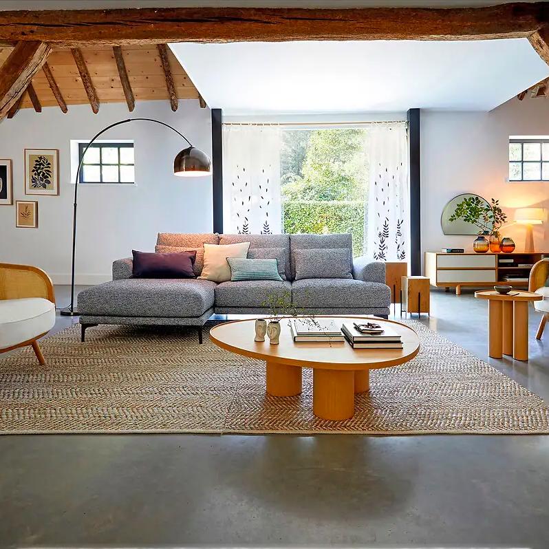 Voor de vorm van deze blank houten salontafel heeft de ontwerper zich laten inspireren door vuurschalen en dat zie je terug in de organisch vormen.