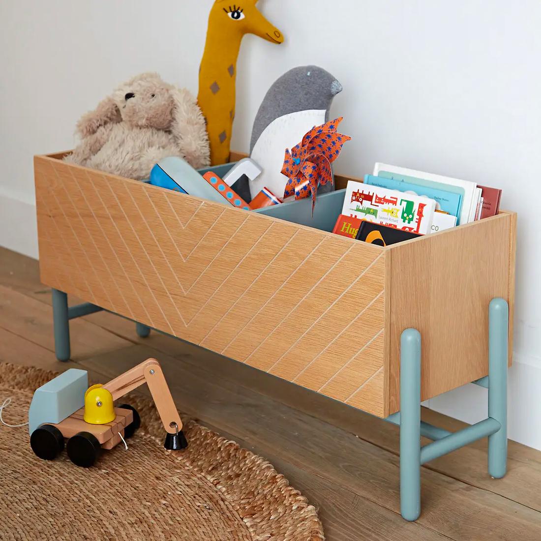 De boekenbox is trendy vormgegeven, met een visgraatpatroon en grijsgroen onderstel.