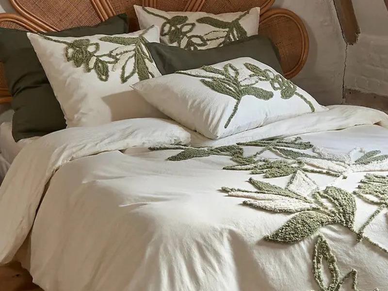 Het katoenen dekbed matcht goed met donkergroene elementen en rotan accessoires. 