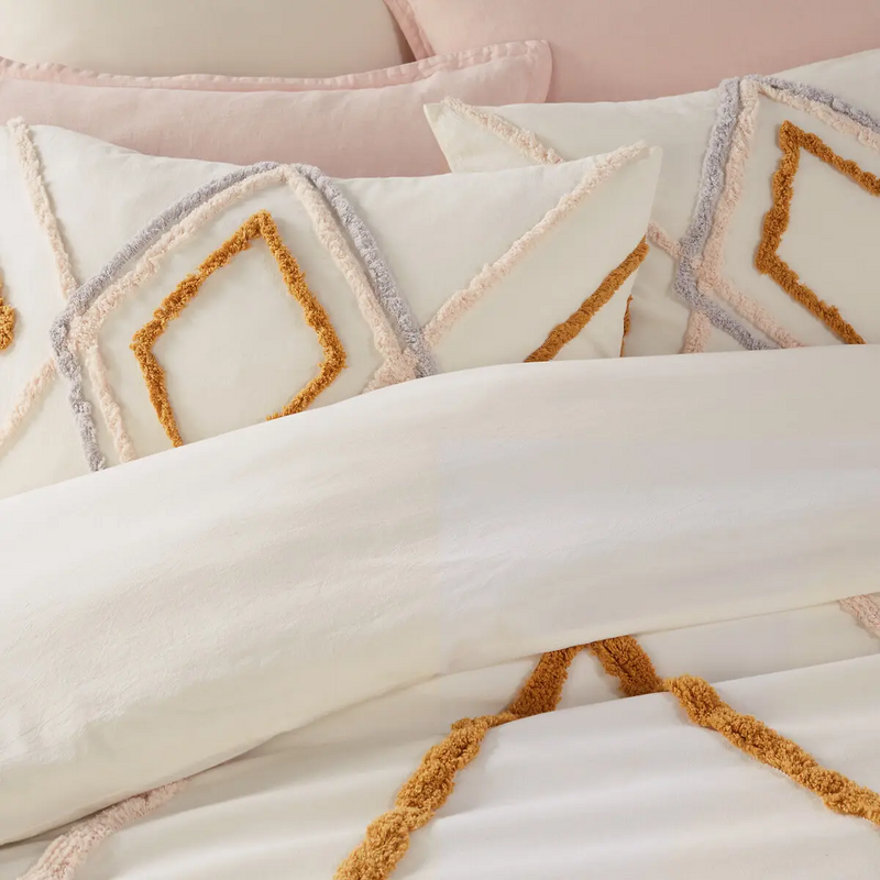 Dit dekbedovertrek en houten en rotan accenten in de slaapkamer maken de bohemian look compleet.