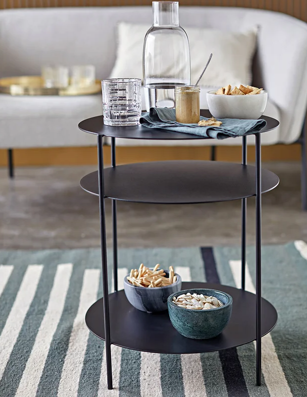 Een zwart ronde bijzettafel is ook handig om een paar flessen drank op kwijt te kunnen. Bovenop zet je de glazen neer, zodat je na een lange dag werken zo een drankje voor jezelf inschenkt. 